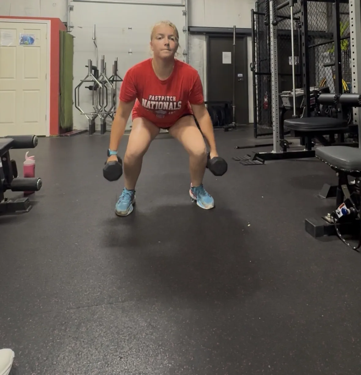 A soccer athlete holding the bottom of a dumbbell squat with both feet flat